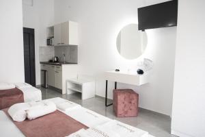 a white room with a bed and a sink at Aeonian Luxury Suites Asprovalta, Adults Only & Kids 12 Plus in Asprovalta