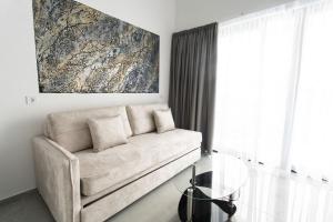 a living room with a couch and a glass table at Aeonian Luxury Suites Asprovalta, Adults Only & Kids 12 Plus in Asprovalta