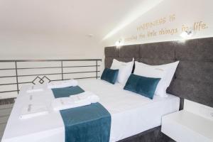 a bedroom with two beds with blue and white pillows at Aeonian Luxury Suites Asprovalta, Adults Only & Kids 12 Plus in Asprovalta