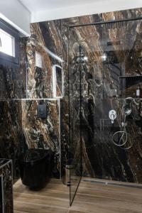 a bathroom with a black marble wall at Aeonian Luxury Suites Asprovalta, Adults Only & Kids 12 Plus in Asprovalta
