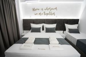 a bedroom with two beds and a sign that reads home is wherever we are together at Aeonian Luxury Suites Asprovalta, Adults Only & Kids 12 Plus in Asprovalta