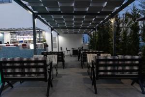 a patio with tables and chairs under a pergola at Aeonian Luxury Suites Asprovalta, Adults Only & Kids 12 Plus in Asprovalta