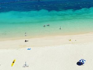 a beach with a group of people in the water at Hotel Monterey Okinawa Spa & Resort in Onna
