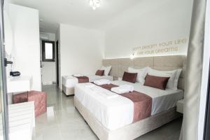 a bedroom with two beds and a mirror at Aeonian Luxury Suites Asprovalta, Adults Only & Kids 12 Plus in Asprovalta
