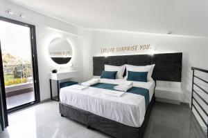a bedroom with a large bed and a large window at Aeonian Luxury Suites Asprovalta, Adults Only & Kids 12 Plus in Asprovalta