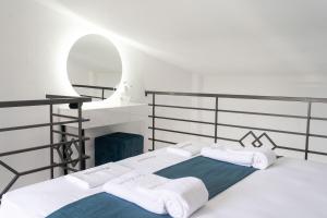 a bedroom with two beds and a mirror at Aeonian Luxury Suites Asprovalta, Adults Only & Kids 12 Plus in Asprovalta