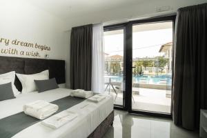 a bedroom with a bed with a view of a pool at Aeonian Luxury Suites Asprovalta, Adults Only & Kids 12 Plus in Asprovalta