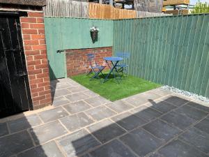 a patio with a table and chairs next to a fence at Laura Ashley cosy inner terrace in Barnsley +6 photos