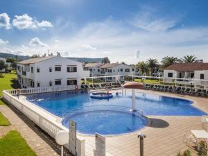 a large swimming pool in front of a house at Cheap & Chic Apartamentos en Son Bou de 2 dormitorios in Son Bou