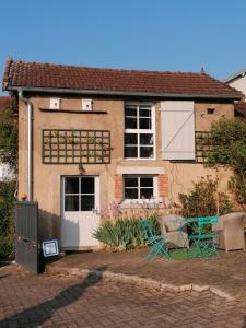 une maison avec une table et des chaises devant elle dans l'établissement Le Garni Vendémiaire, à Vesoul