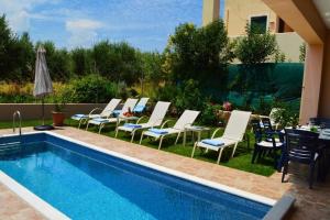 um grupo de cadeiras e uma piscina em Belle Verte Villa Maleme em Maleme