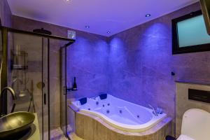 a purple bathroom with a tub and a shower at orel's Top apartment in Eilat +45 photos