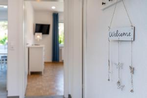 a welcome sign on a door in a room at Haus Pirola Esens in Esens