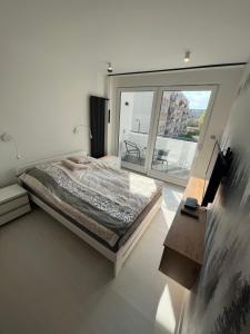 a bedroom with a bed and a large window at BlaBlaFlat Świnoujście Witosa in Świnoujście