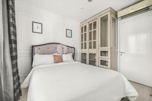 a white bedroom with a white bed and a window at Palais by Kozystay - Thamrin in Jakarta +18 photos