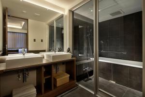 a bathroom with a tub, sink, mirror and bathtub at 22 PIECES in Kyoto