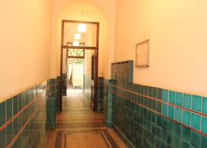 ein Badezimmer mit grünen Fliesen an den Wänden und einen Flur in der Unterkunft Apartments-Maison Am Olivaer Platz in Berlin