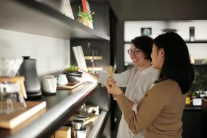 two women standing at a counter in a restaurant at 22 PIECES in Kyoto