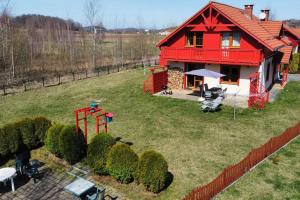 a red house with a playground in the yard at Villa Leika - Panoramablick am Riesengebirge in Mysłakowice
