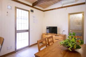 a dining room with a table and a tv and a window at Camping Linus in Marina di Massa