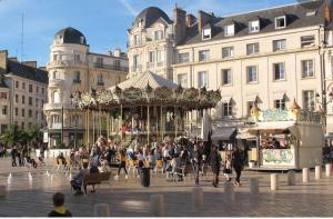 een groep mensen in een stad met een draaimolen bij Le Palace in Orléans