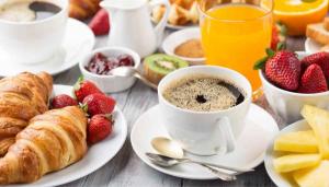 een ontbijttafel met een kopje koffie en aardbeien bij Le Palace in Orléans