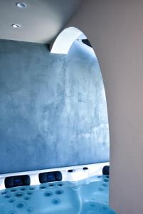 Villa Galaxy Santorini في فيرا: حمام بحائط ازرق وحوض استحمام