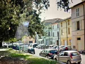 a row of cars parked on a street with buildings at Casa Europa in Faenza