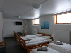 SangisにあるSangis Motell och Campingのベッド4台、テーブルと椅子が備わる客室です。