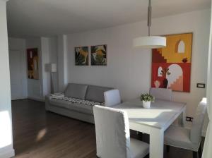 sala de estar con mesa blanca y sofá en ATALAYA SUNSET terrazza panoramica privata con vista al mare, en Corralejo