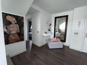 una sala de estar con una pintura en la pared y un espejo en ATALAYA SUNSET terrazza panoramica privata con vista al mare, en Corralejo