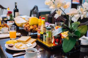 una mesa con comida y bebida en una mesa con queso y fruta en Joye Hotel, en Hanói