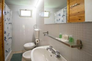 a white bathroom with a toilet and a sink at Camping Linus in Marina di Massa +88 photos