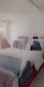 a white bed with a mosquito net on it at The Dream Resort in Ella