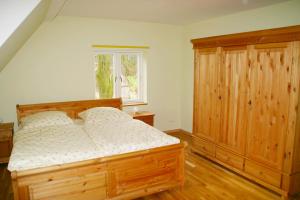 Schlafzimmer mit einem Holzbett und einem Holzschrank in der Unterkunft Hof Viehbrook in Hollenbek