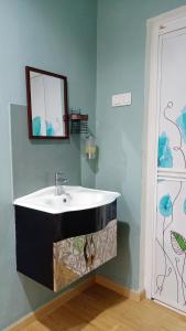 a bathroom with a sink and a mirror at The Maple Homestay @ Kota Laksamana Melaka in Melaka