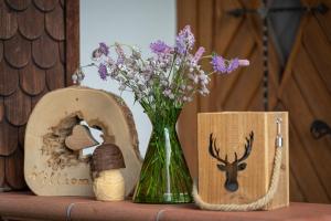 zielona waza z kwiatami siedząca obok drewnianych pudełek w obiekcie Chalet Abnona w mieście Wieden