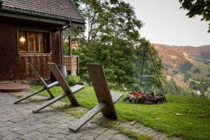 two wooden chairs sitting in front of a fire at Chalet Abnona in Wieden