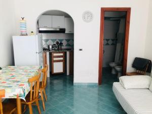 a kitchen and dining room with a table and a refrigerator at Casetta Forio in Forio d'Ischia
