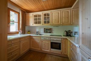 a kitchen with wooden cabinets and a sink and a window at Chalet Abnona in Wieden +28 photos