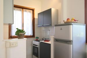 eine Küche mit einem Kühlschrank und einem Herd in der Unterkunft PIETRASANTA-VERSILIA - Delizioso Cottage al mare in Pietrasanta