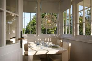 uma sala de jantar com uma mesa branca e janelas em PIETRASANTA-VERSILIA - Delizioso Cottage al mare em Pietrasanta