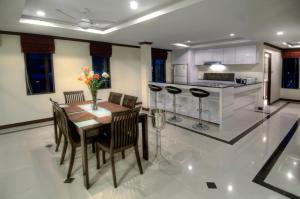 a kitchen and dining room with a table and chairs at Emerald Beach-Front Apartments Fishermans Village in Koh Samui 