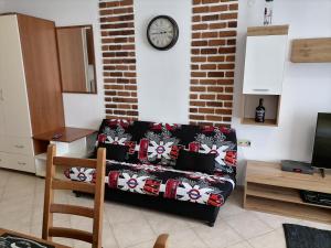 a living room with a couch and a clock on the wall at Apolon 2 in Sozopol