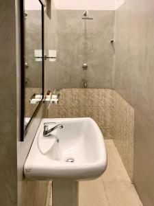une salle de bain avec un lavabo blanc et un miroir dans l'établissement Mendila Cityscape Hikkaduwa, à Hikkaduwa