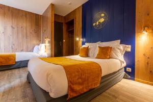 sypialnia z 2 łóżkami i niebieskimi ścianami w obiekcie Grand Hôtel 1899 w mieście Langogne