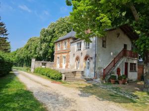 una casa vieja en un camino de tierra al lado de una entrada en La Fuye du Chateau de Jallanges pour 17 personnes, en Vernou-sur-Brenne