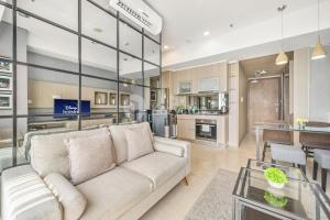 a living room with a couch and a kitchen at Quarter by Kozystay - Setiabudi in Jakarta