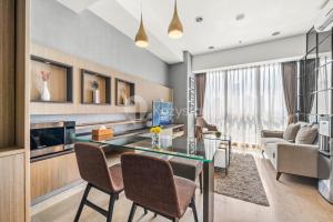 a living room with a glass table and chairs at Quarter by Kozystay - Setiabudi in Jakarta