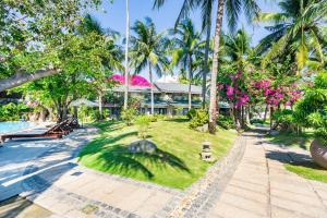 a resort with a pool and palm trees at Hoang Ngoc Beach Resort in Mui Ne